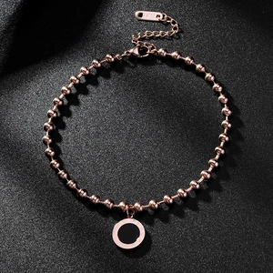Macro shot of rose gold stainless steel bracelet featuring a Roman numeral round charm