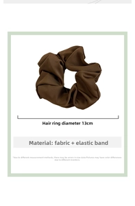 Detail view of brown satin scrunchie showing a 13cm diameter with elastic fabric texture
