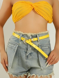 Detail of bright yellow leather belt with silver needle buckle on denim shorts