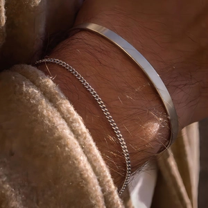 Men's double-layered silver cuban chain and cuff bracelet set on a male wrist