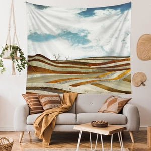 Close-up of abstract mountain landscape tapestry hanging above a grey sofa