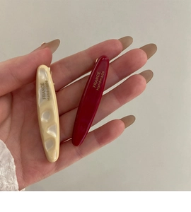 Détails des barrettes en acétate crème et bordeaux avec inscription dorée faite main