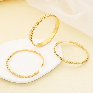 Three 18K gold plated stainless steel oval bangles with white zircon inlays on decor stones