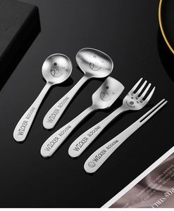 Detail of five-piece stainless steel kids cutlery set with smiley faces and engravings