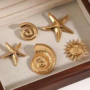 Golden ocean series brooches with starfish and sun motifs in a wooden jewelry box