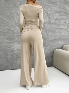 Back view of a beige long-sleeve crop top and wide-leg knit trousers set with off-shoulder cut