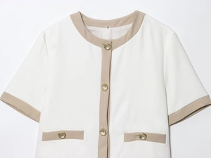 Detailed close-up of white short-sleeved blazer with gold buttons and beige trim