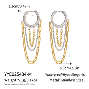 Detail view of tiered tassel earrings with silver hoop and multi-layered chain fringe