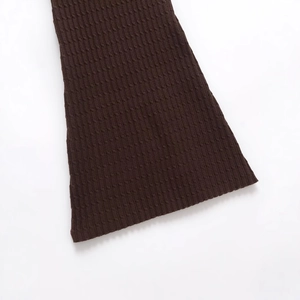 Dunkelbraunes Strickkleid mit Zopfmuster und ausgestellten Ärmeln auf weißem Grund