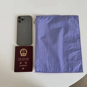 Purple nylon organizer pouch with zipper shown with a phone and passport for scale