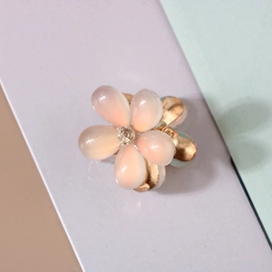Detailed macro view of a pink resin flower hair claw clip with a sparkling center rhinestone
