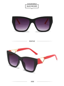 Detail view of square sunglasses with black frames, red temples, and purple gradient lenses