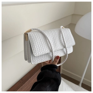 Detail of white woven texture leather bag with elegant gold hardware and V-pattern craft