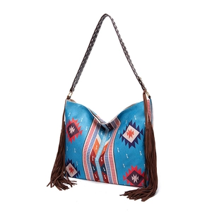 Close-up of bohemian blue tote bag with geometric patterns and long brown tassels