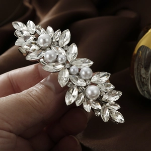 Close-up of marquise-cut rhinestones and white pearls on silver spring hair clip