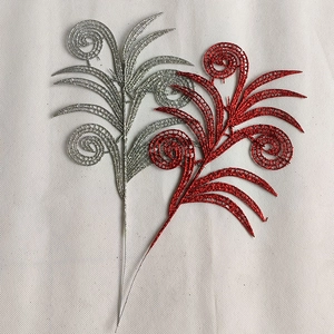 Macro detail of red and silver hollow glitter leaves for festive Christmas tree decor