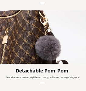 Detailed macro view of monogram pattern faux leather bag with detachable grey faux fur ball
