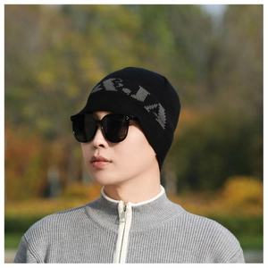 Detail of black knit beanie featuring grey jacquard lettering pattern for winter style
