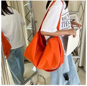 Close-up of bright orange waterproof oxford cloth shoulder bag with glossy nylon texture