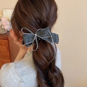Elegant black glitter bow hair claw clip with zircon detail shown on back of hair