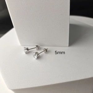 Macro shot of 5mm silver stainless steel stud earring with clear six-prong cubic zirconia