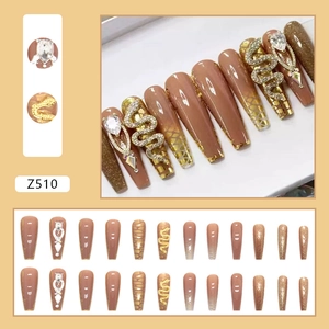 Long ballet press-on nails in nude brown with gold snake charms and teardrop rhinestones