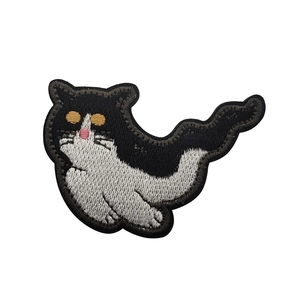Close-up of cute cat holding knife embroidered patch with sharp black and white textures