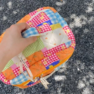 Detailed shot of quilted patchwork makeup bag with floral patterns and sturdy handle