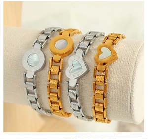 Detailed macro view of 18K gold and silver bracelets with Roman numeral shell pendants