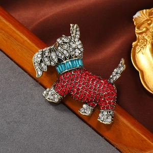 Vintage gold dog brooch with red rhinestones and crystal accents on velvet background
