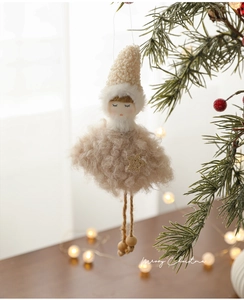 Detail of plush Christmas angel ornament with gold star dress hanging on a festive tree