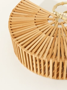 Detailed close-up of handmade semi-round hollow bamboo woven handbag with bamboo root handle