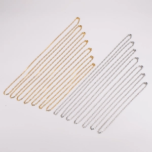 Minimalist gold and silver paperclip link necklaces arranged neatly on a white background