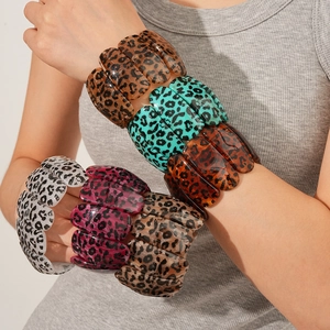 Détail de bracelets joncs en acrylique à imprimé léopard coloré portés sur le poignet