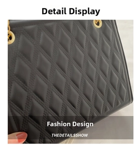 Close-up detail of luxury black quilted leather tote bag with gold metal eyelets