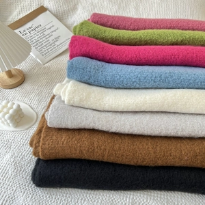 Close-up of neatly folded soft cashmere-feel scarves in various vibrant colors