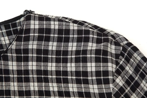 Détail de la chemise à carreaux noir et blanc avec coupe d'encolure et zip discret