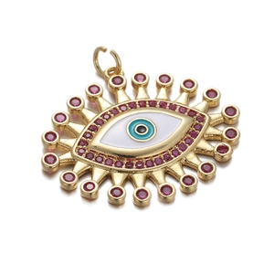 Golden Evil Eye pendant with blue enamel center and pink gemstones on white background