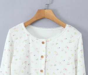 Détail d'un cardigan floral tricoté avec bordure dentelle, boutons bois et texture gaufrée