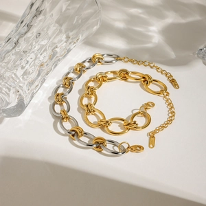 Modern two-tone gold and silver stainless steel chunky chain bracelet on white background