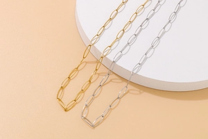 Close-up of interlocking oval link gold and silver titanium steel necklaces set