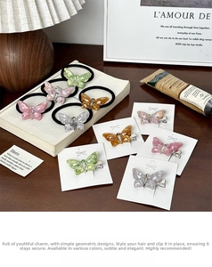 Détail de pinces à cheveux papillon et d'élastiques avec strass sur une table en bois