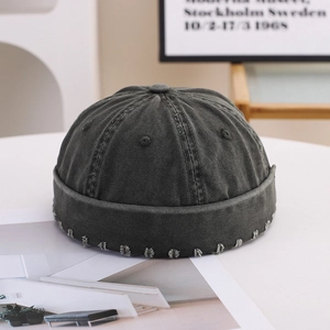 Retro charcoal grey cotton docker hat with vintage distressed edges in minimalist setting
