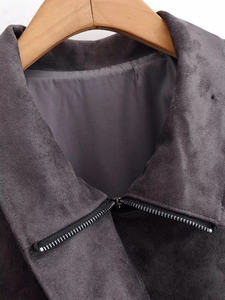 Gros plan d'un col de veste en daim gris foncé avec fermeture éclair et texture du tissu