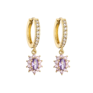Detailed macro view of gold flower earrings with purple zircon and pink gemstones