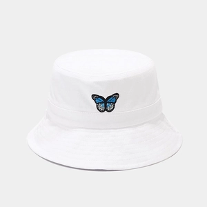 Close-up of intricate blue butterfly embroidery on a white cotton bucket hat detail