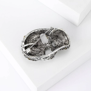 Detailed back view of a silver skull brooch showing the alloy texture and pin fastener
