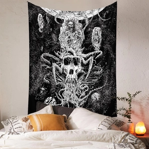 Bohemian black and white skull tapestry hanging over a bed on a white brick wall
