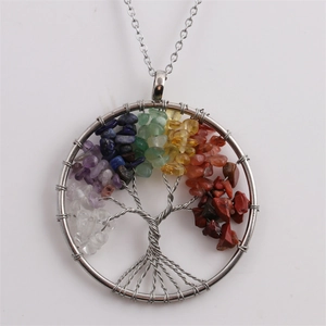 Close-up of tree of life pendant with colorful natural stones and silver wire wrapping