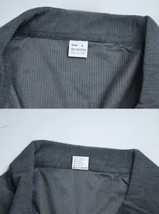 Detail view of the gray corduroy shirt's inner label showing 100% polyester fabric material